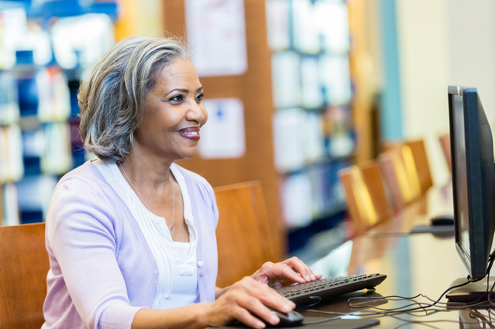 Image of a smiling woman using a computer (iStock/SDI Productions)